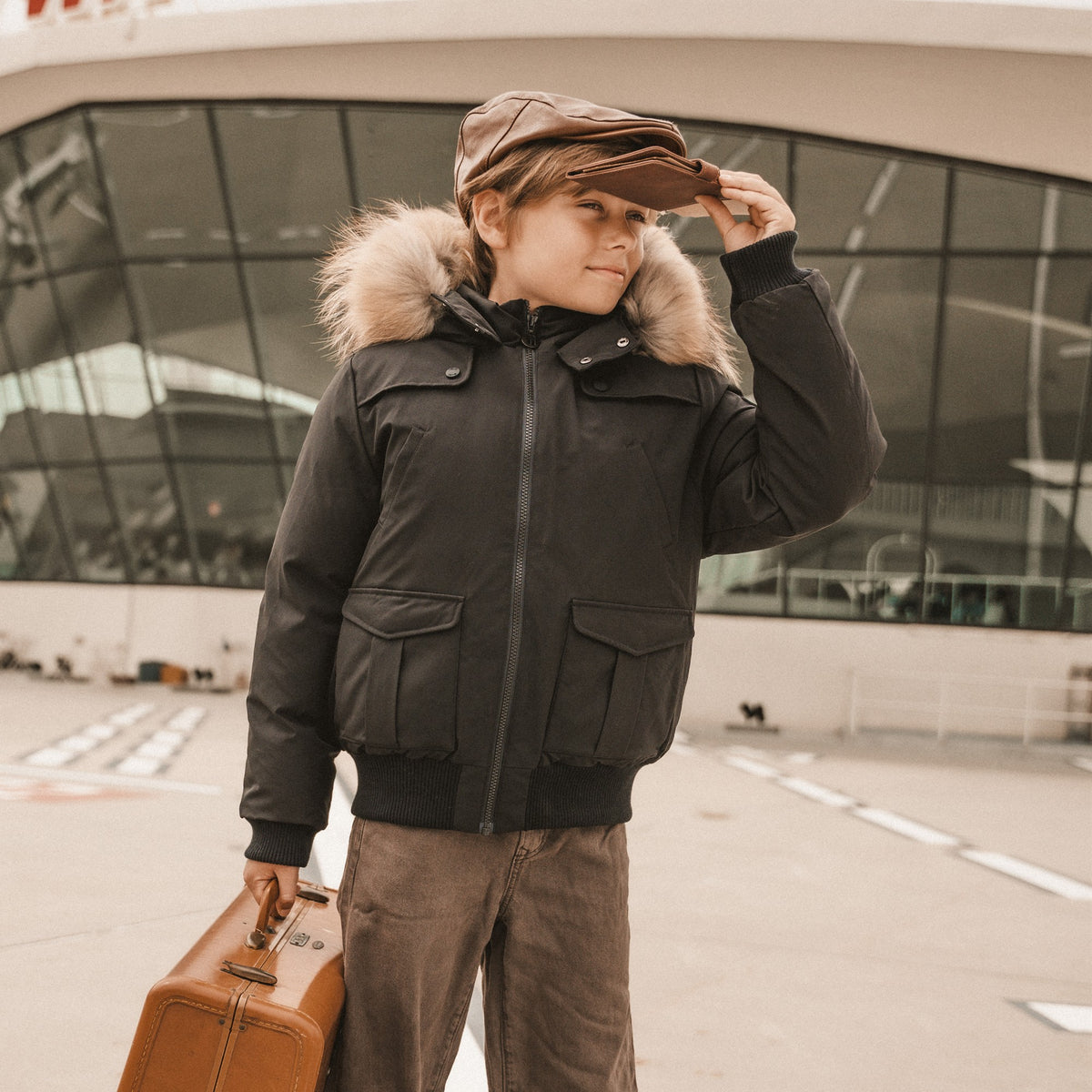 IBIS boys collection - boy in black down bomber with fur hood and leather cap