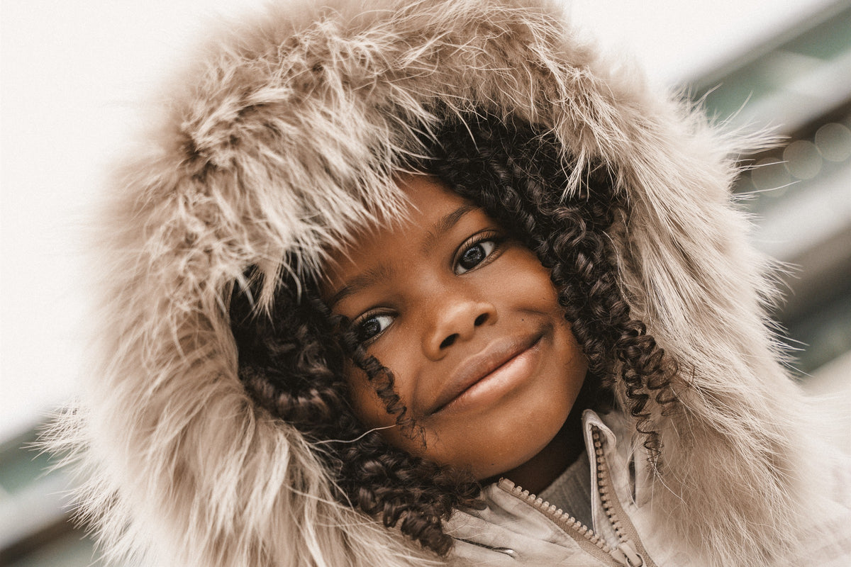 Smiling girl framed by a large fur hood on a winter coat